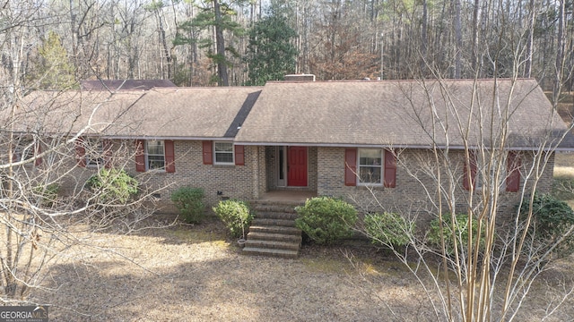 ranch-style home with brick siding and roof with shingles