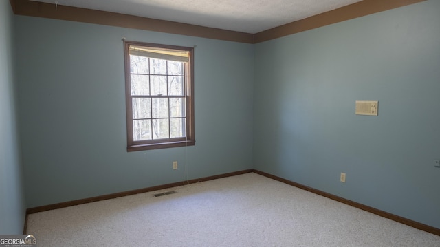 unfurnished room with baseboards, a textured ceiling, visible vents, and carpet flooring