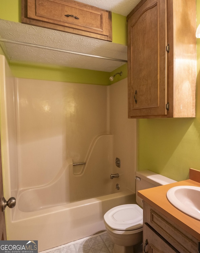 bathroom featuring toilet,  shower combination, a textured ceiling, and vanity