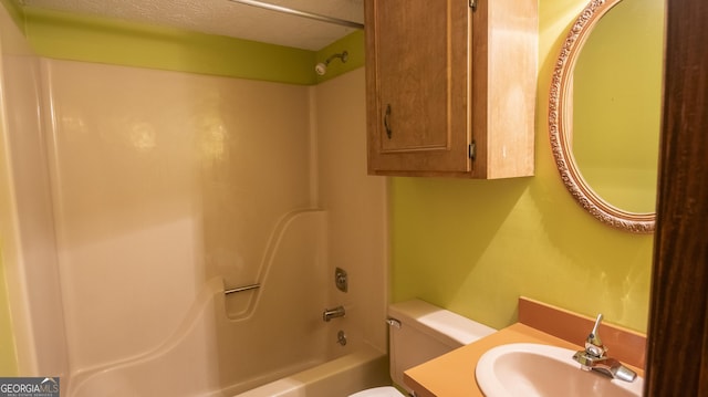 full bath featuring bathtub / shower combination, vanity, toilet, and a textured ceiling