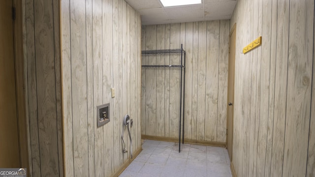 washroom featuring laundry area, wood walls, and light floors