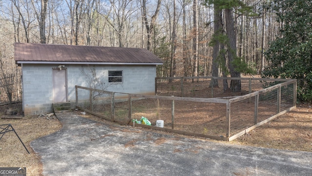 exterior space featuring an outdoor structure, fence, and a gate