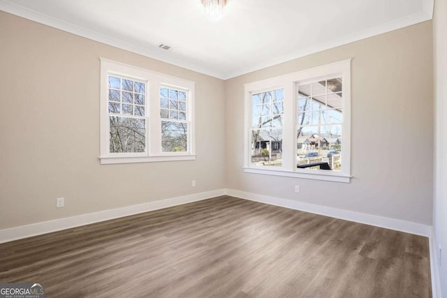 unfurnished room with crown molding, baseboards, and dark wood-style flooring