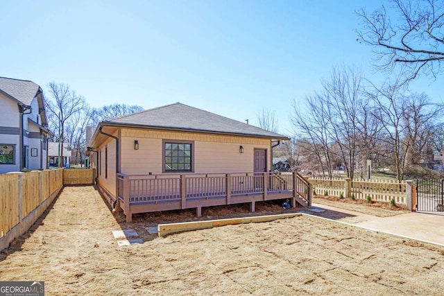 back of house with a fenced backyard and a wooden deck