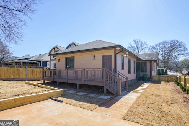 back of property with a deck, a patio, and fence private yard