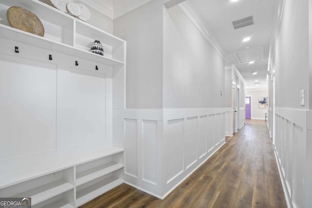 mudroom with dark wood-style floors, attic access, visible vents, and crown molding