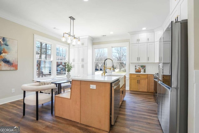 kitchen featuring appliances with stainless steel finishes, dark wood-type flooring, light countertops, crown molding, and a sink