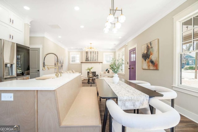 dining room featuring dark wood finished floors, recessed lighting, ornamental molding, a chandelier, and baseboards