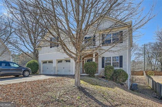 view of front of property featuring a garage, concrete driveway, and fence