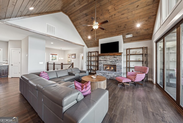 living area with visible vents, wooden ceiling, dark wood-type flooring, a stone fireplace, and high vaulted ceiling