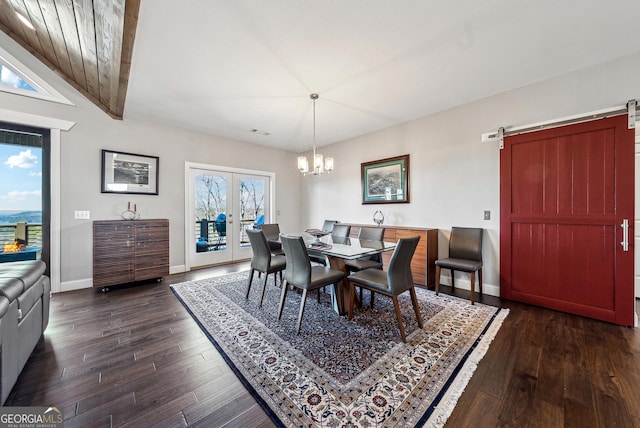 dining room featuring a barn door, dark wood-type flooring, baseboards, french doors, and an inviting chandelier