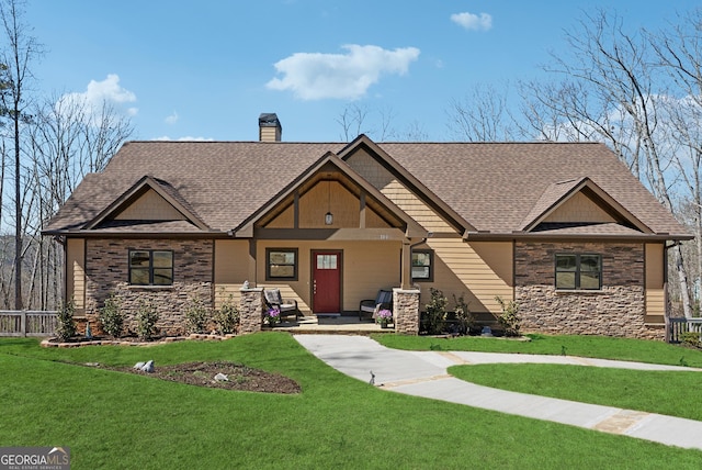 craftsman-style home featuring stone siding, a shingled roof, a chimney, and a front yard