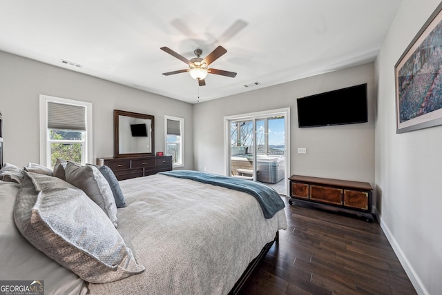 bedroom featuring access to outside, multiple windows, visible vents, and dark wood-type flooring