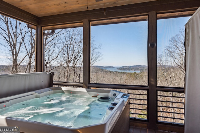 sunroom / solarium featuring wood ceiling, a healthy amount of sunlight, and a hot tub