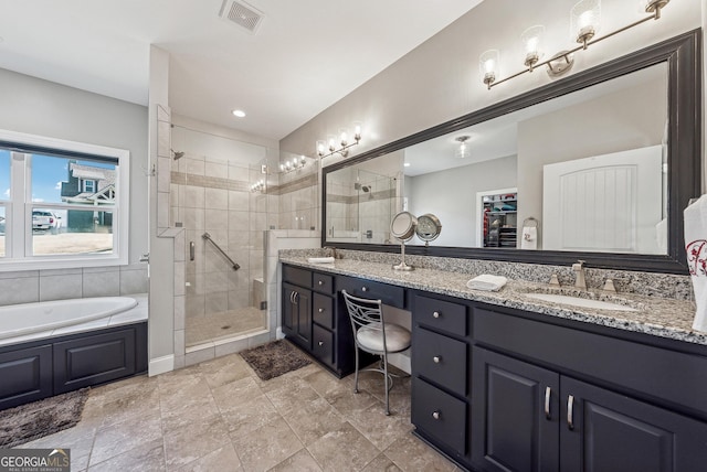 bathroom featuring a garden tub, a sink, a shower stall, and double vanity