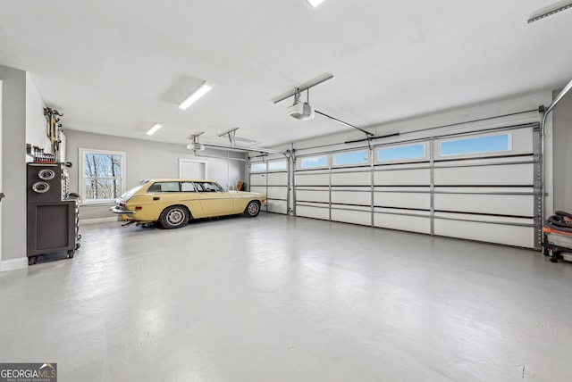 garage with baseboards and a garage door opener