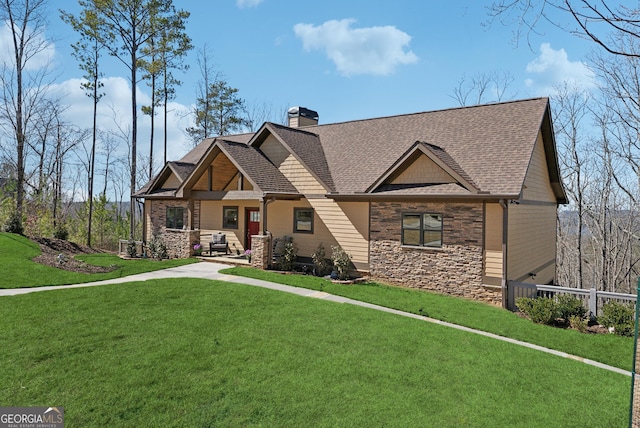 craftsman-style house with roof with shingles, a chimney, a front yard, fence, and stone siding