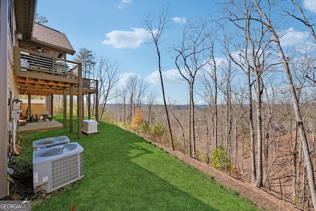 view of yard featuring a patio area, a wooden deck, and central air condition unit