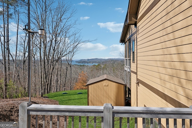 view of yard with a forest view, a shed, and an outdoor structure