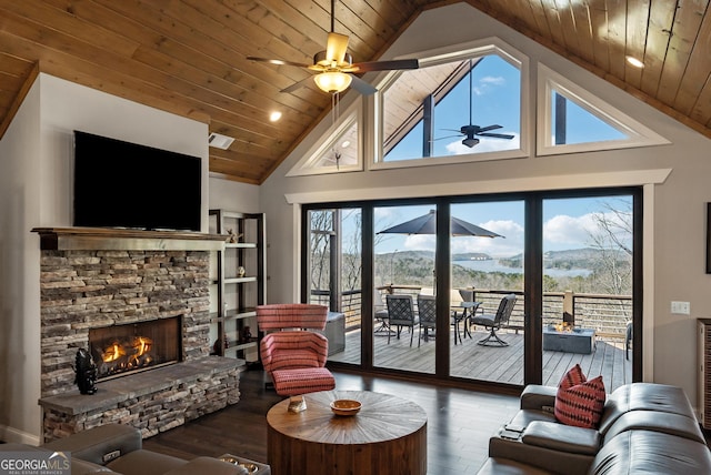 living area with visible vents, a ceiling fan, a stone fireplace, wood finished floors, and wooden ceiling