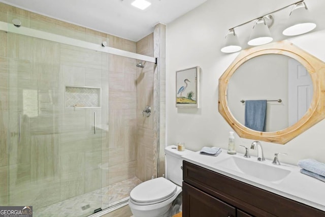 bathroom featuring toilet, a stall shower, and vanity