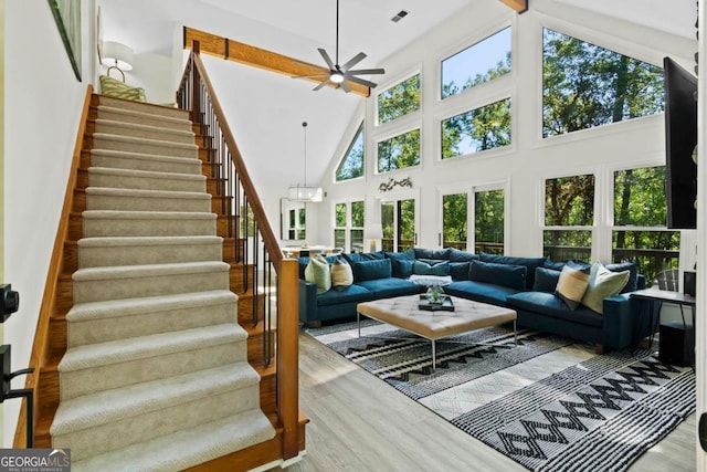 living room with stairway, wood finished floors, visible vents, and a healthy amount of sunlight