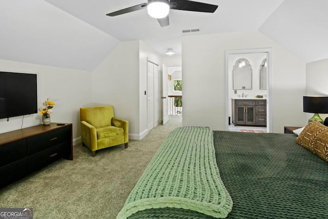 carpeted bedroom with visible vents, a ceiling fan, connected bathroom, vaulted ceiling, and a sink