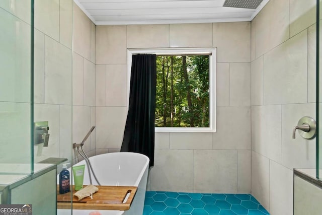 bathroom featuring a freestanding tub and tile walls