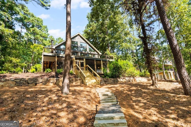 rear view of house featuring stairs and a wooden deck