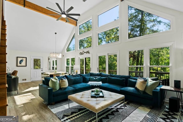 sunroom / solarium with a healthy amount of sunlight, vaulted ceiling with beams, and ceiling fan