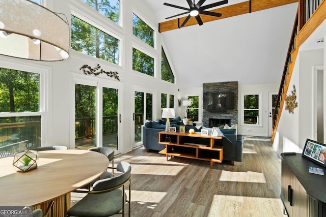 sunroom / solarium with a fireplace, lofted ceiling with beams, and ceiling fan