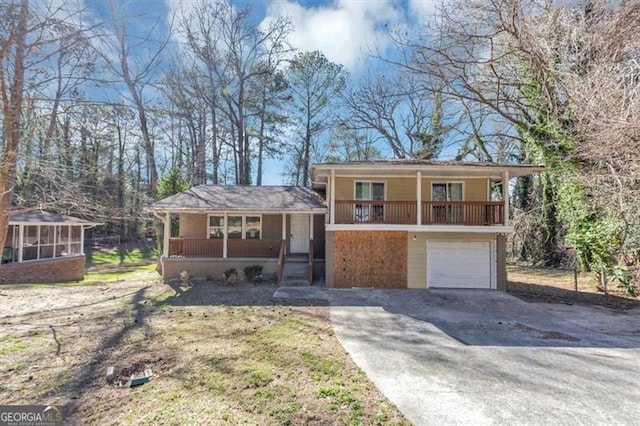 tri-level home with an attached garage, covered porch, and concrete driveway