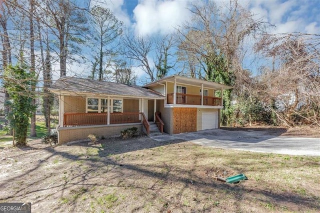 tri-level home featuring covered porch, driveway, and a garage