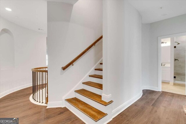 staircase with recessed lighting, wood finished floors, and baseboards