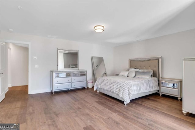 bedroom with wood finished floors and baseboards