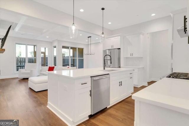 kitchen featuring recessed lighting, a sink, wood finished floors, light countertops, and appliances with stainless steel finishes