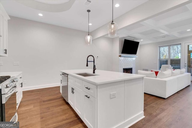 kitchen with stainless steel appliances, visible vents, a sink, wood finished floors, and baseboards