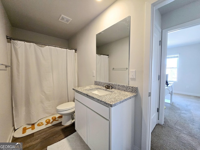 full bath with toilet, vanity, visible vents, and baseboards