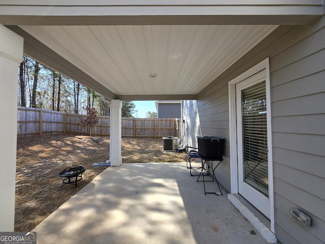 view of patio with an outdoor fire pit, a fenced backyard, and central AC