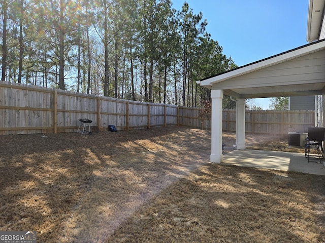 view of yard with a patio area, a fenced backyard, and central AC