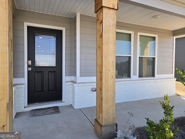 view of exterior entry with brick siding