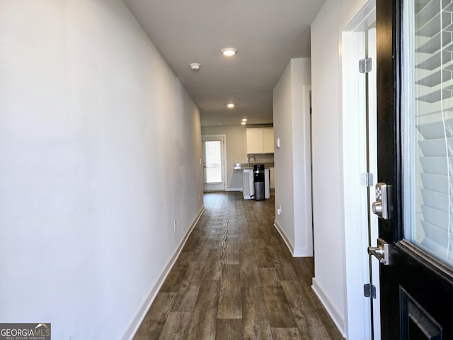 corridor featuring dark wood-style floors, recessed lighting, and baseboards