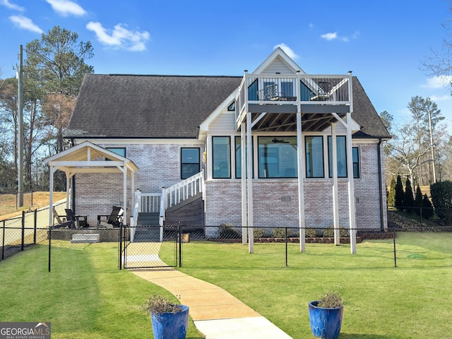 view of front of house featuring fence private yard, a gate, brick siding, and a front lawn