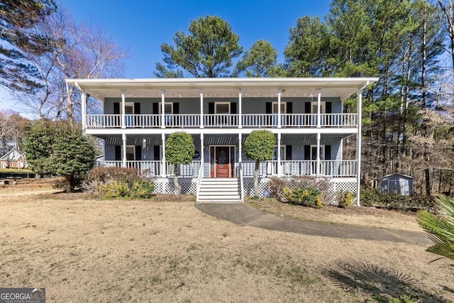 view of front facade with covered porch, an outbuilding, and a balcony