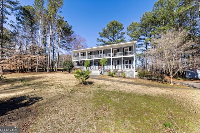 colonial home with covered porch and a front yard