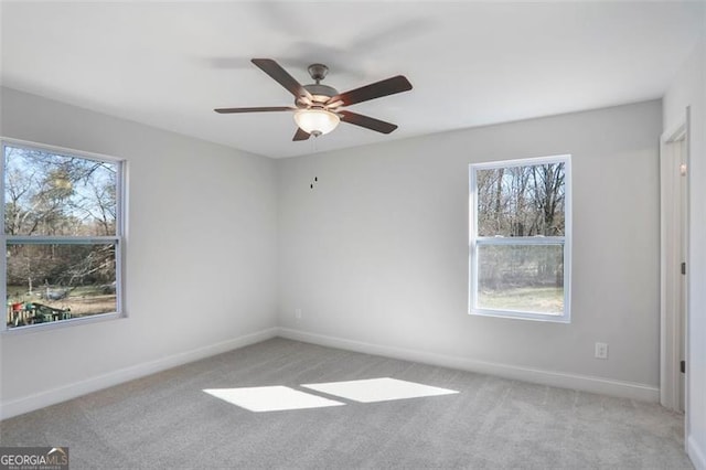 carpeted spare room featuring a wealth of natural light and baseboards