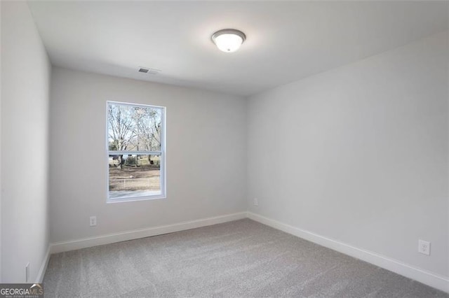 empty room featuring carpet, visible vents, and baseboards