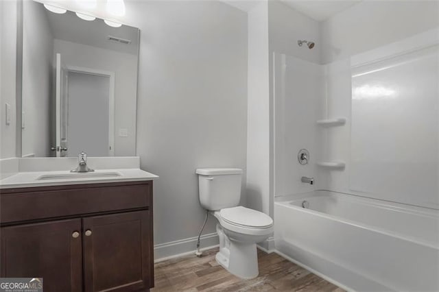 bathroom featuring bathtub / shower combination, toilet, wood finished floors, visible vents, and vanity