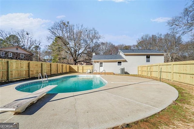 view of pool with a diving board, a patio area, a fenced backyard, and a fenced in pool