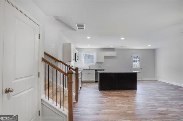 kitchen featuring white cabinetry, visible vents, a wealth of natural light, and a center island